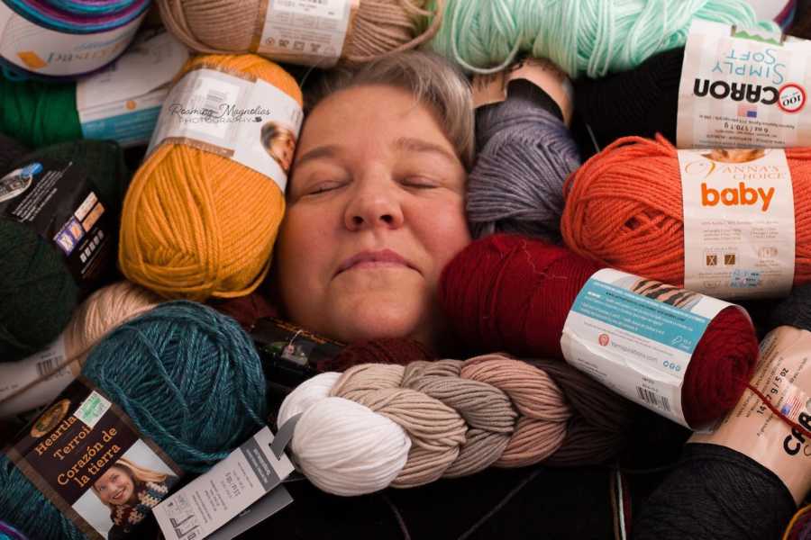 Woman's face surround by bundles of yarn