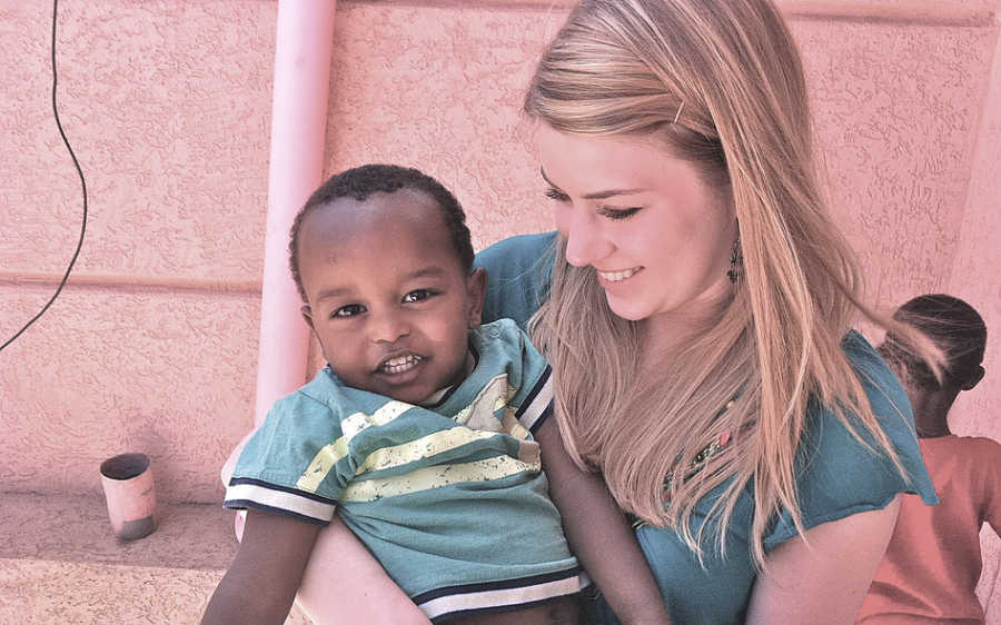 Mother smiles as she holds Ethiopian oprhan