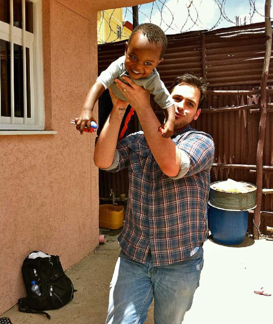 Man holds up Ethiopian orphan in Superman pose