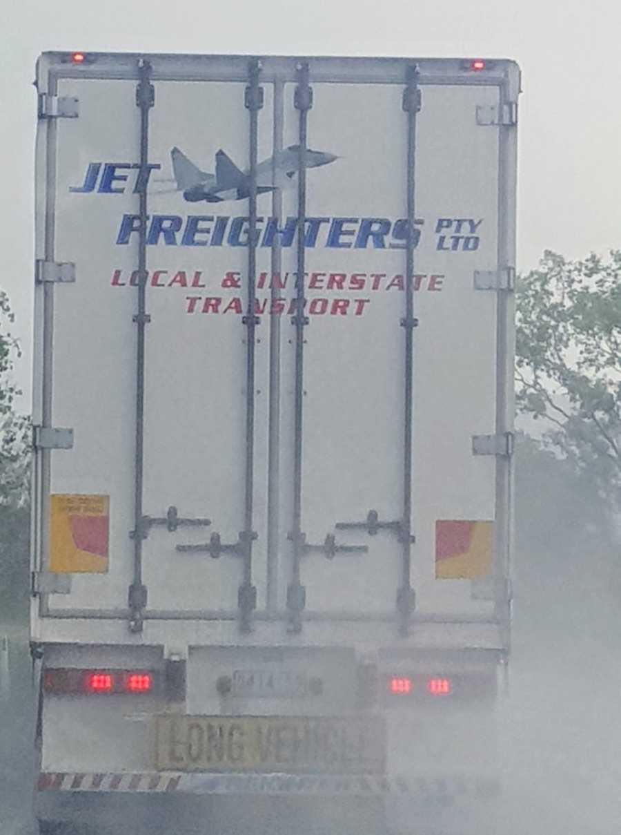 Back of truck on highway guiding cars through storm