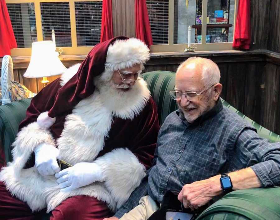 Mall Santa sitting on couch laughing with WWII veteran