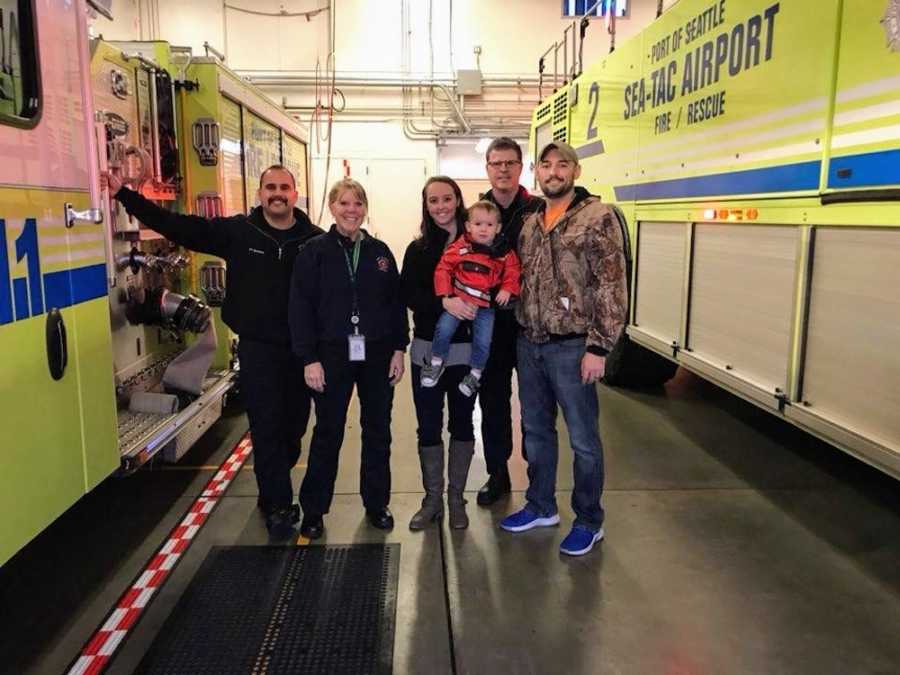Husband and wife stand with their son beside EMT's who took them from airport to hospital after woman gave birth