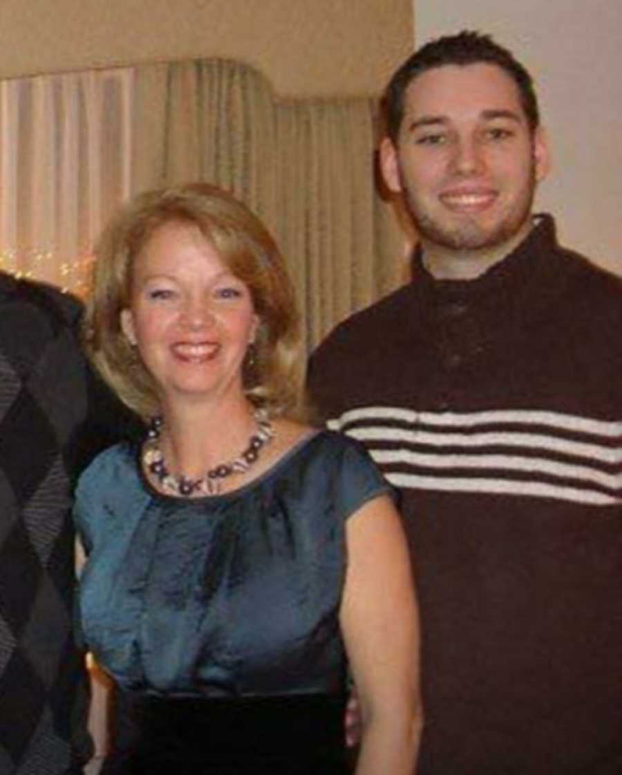 Woman stands smiling beside her son who has since passed away 