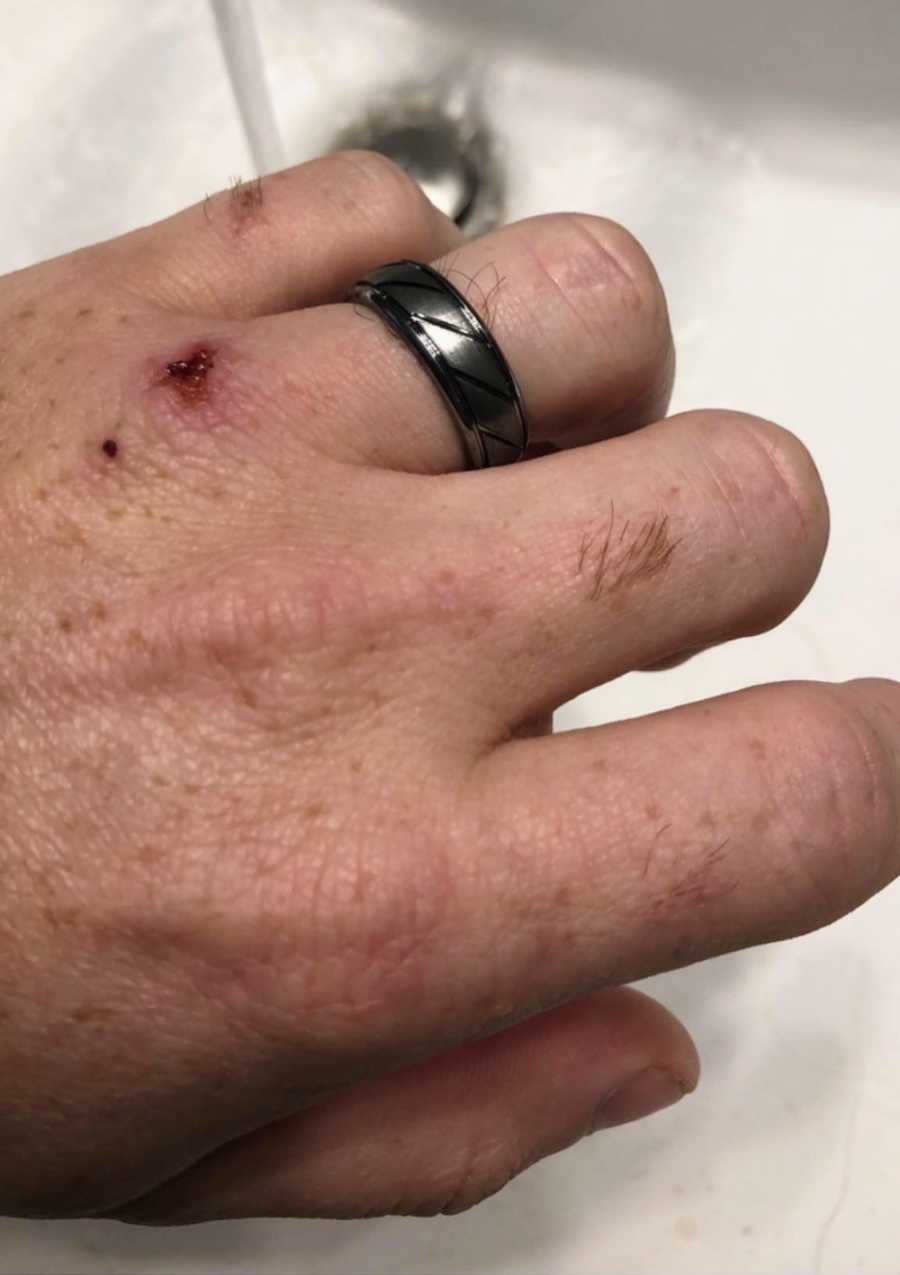 Close up of mans black wedding ring on his finger