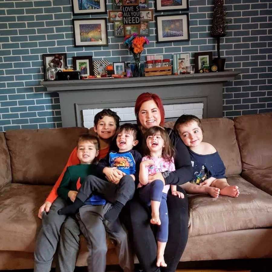 Mother sits on couch in home with five kids, one of which will never be able to walk