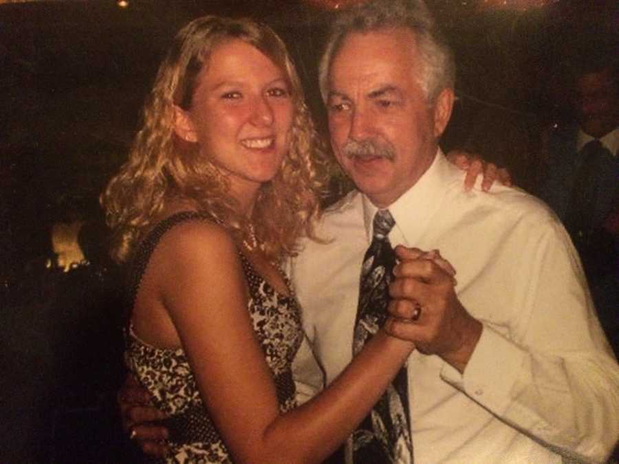 Daughter smiles as she dances with father 