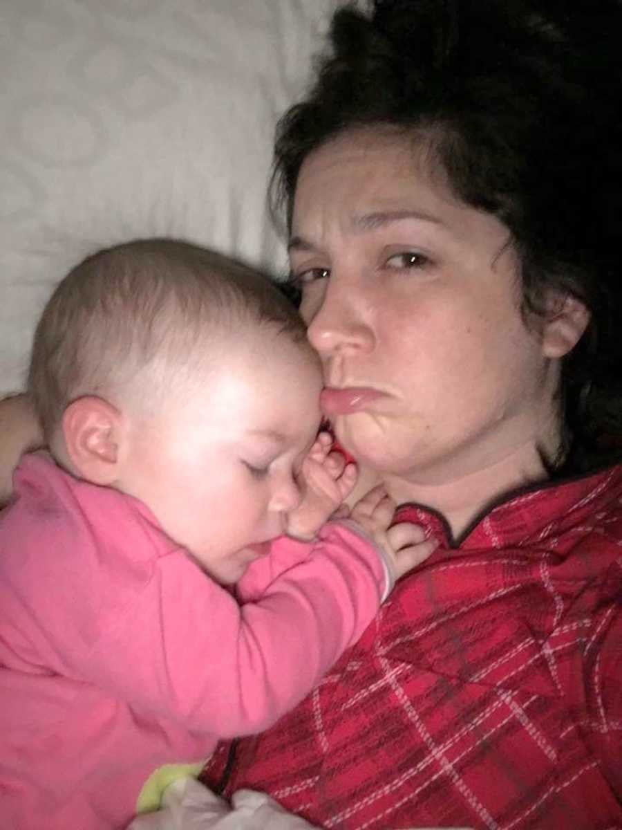 Mother who needs her moms help makes pouty face in selfie while baby sleeps on her chest