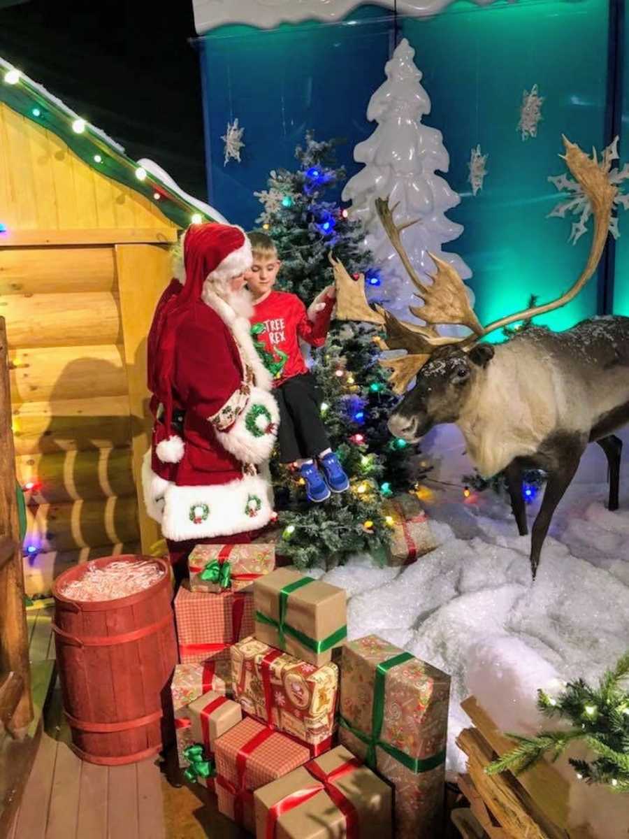 Mall Santa holds young boy who is blind and autistic so he can touch fake reindeer's antler