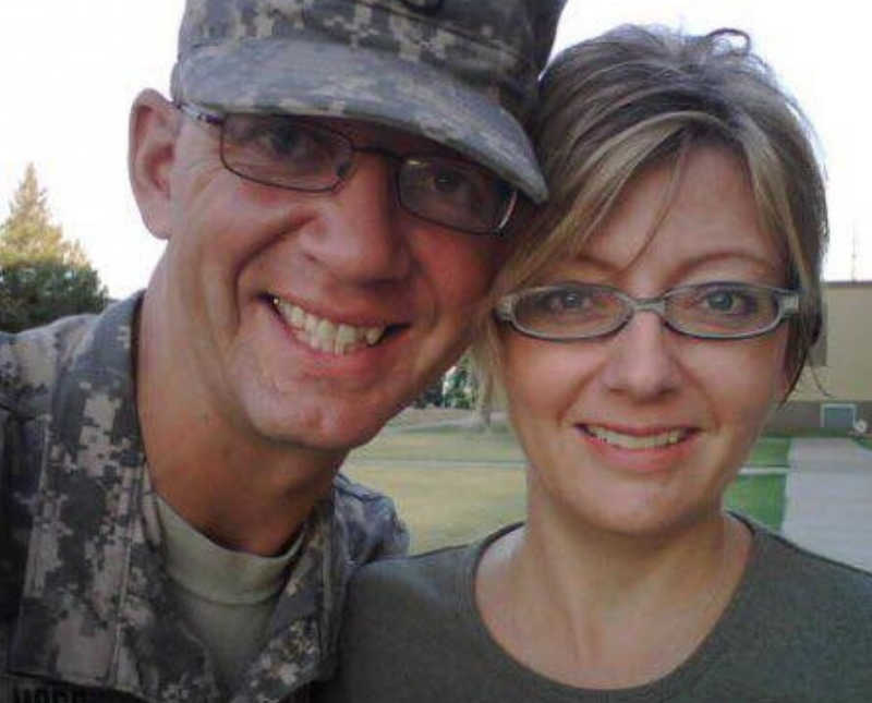 Sergeant stands smiling with wife beside 