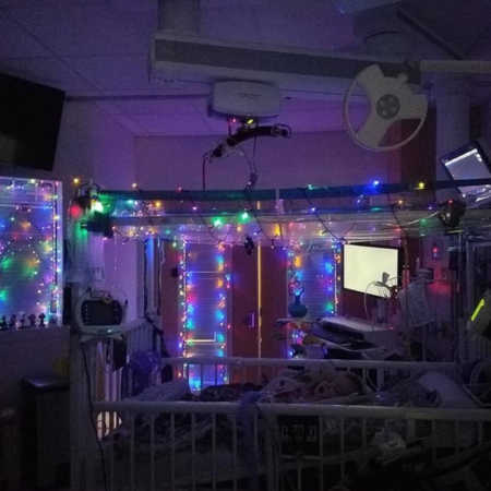 PICU room of baby with trach decorated in colorful Christmas lights