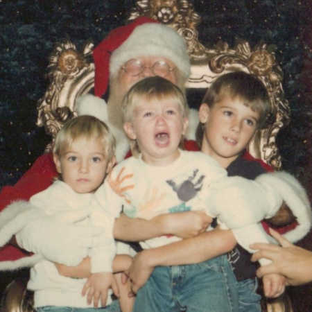Mall Santa sits with three kids in his lap