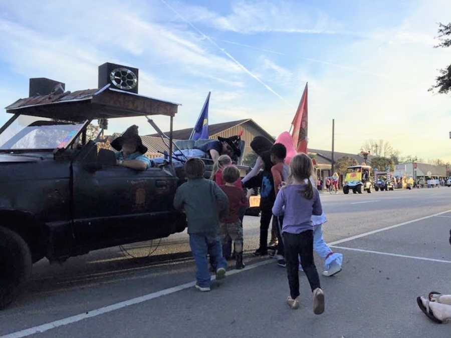 Children walking up to truck that is driving in parade