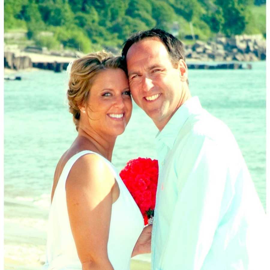 Bride and groom stand smiling with Lake Michigan in background