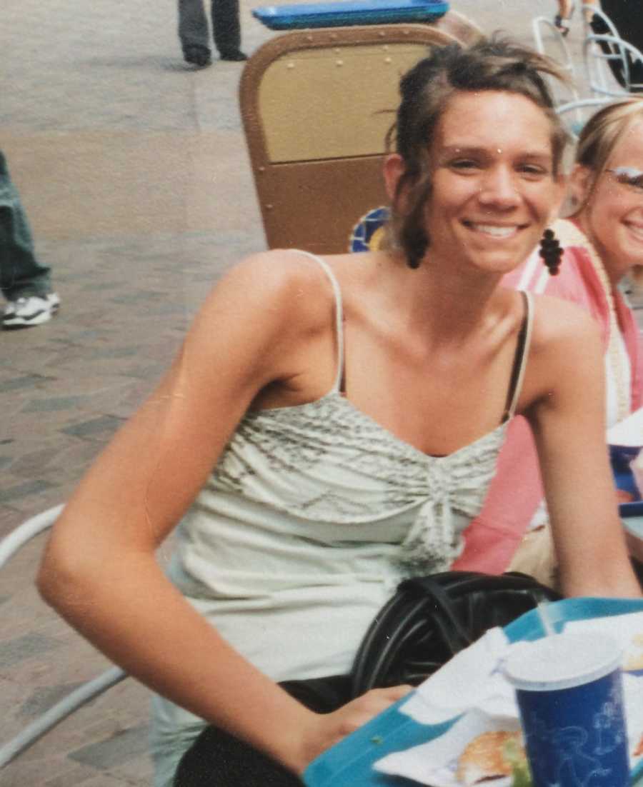 Woman with eating disorder smiles while sitting at table outside