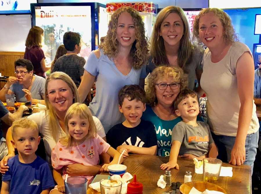 Woman sits at restaurant table on the anniversary of her husbands death with four daughters and their children