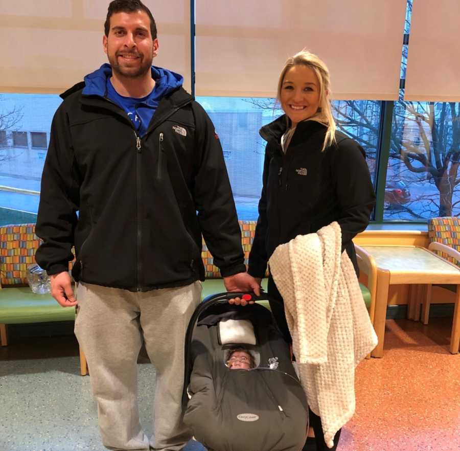 Husband and wife hold newborn with Cornelia de Lange syndrome in car seat