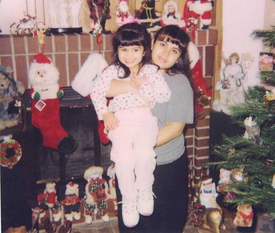 Little sister is held by older sister who has since passed away in home decorated for Christmas