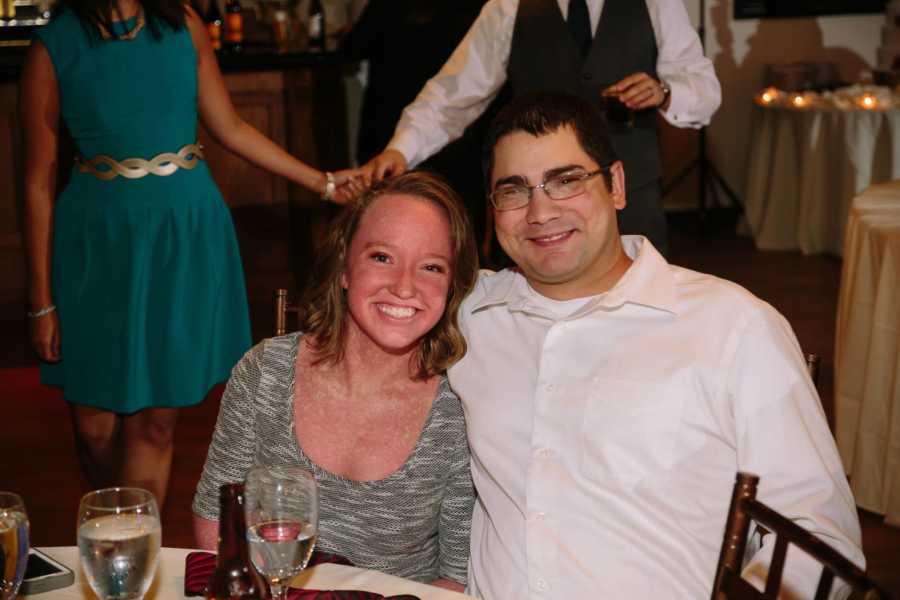 Girlfriend with Ichthyosis and boyfriend sits at table smiling at event