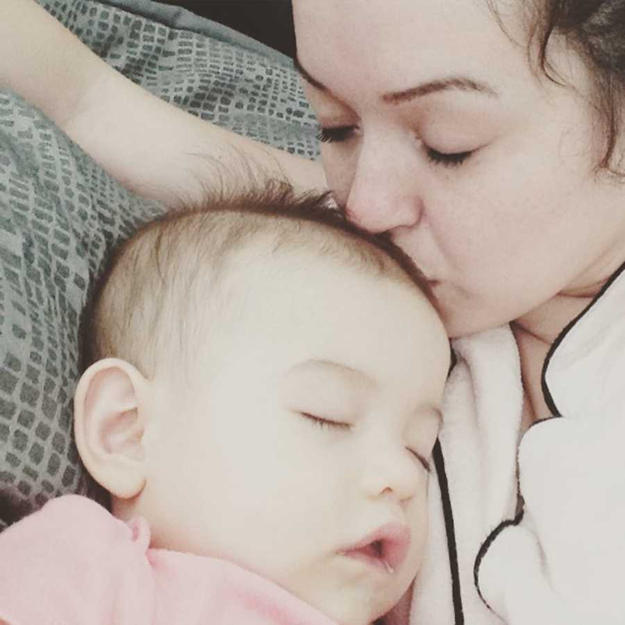 Mother lays kissing head of baby daughter who was shaken