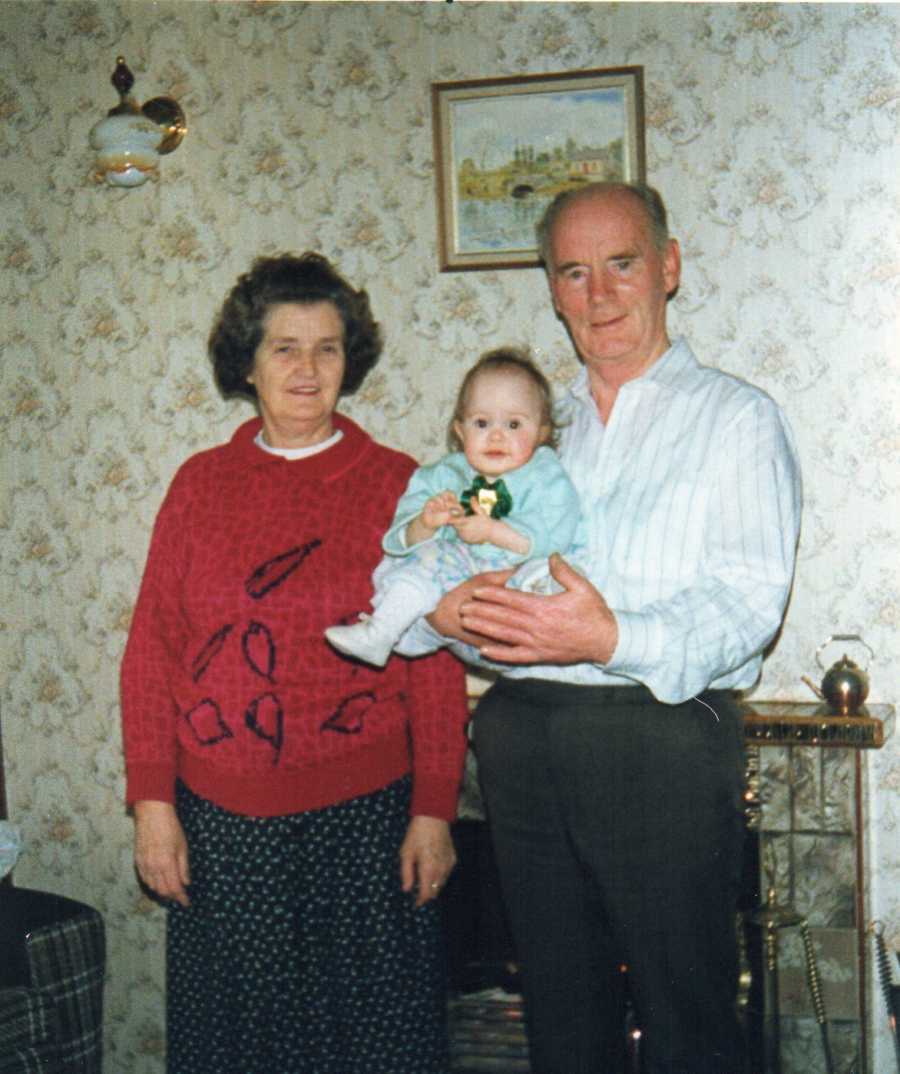 Grandparents smiles as grandfather holds baby with Exomphalos