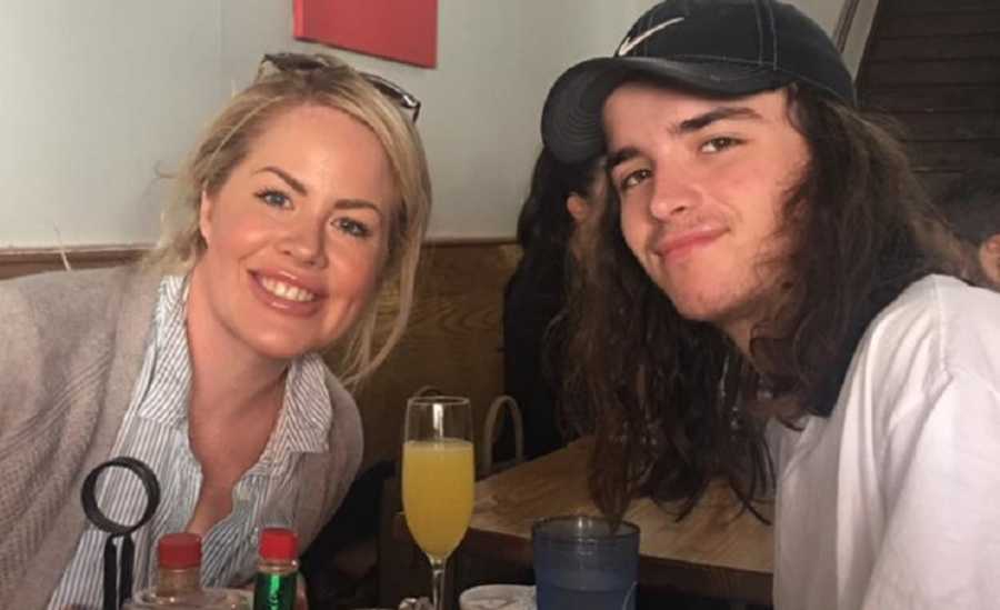 Mother smiles at restaurant table with son who has since passed from drug overdose