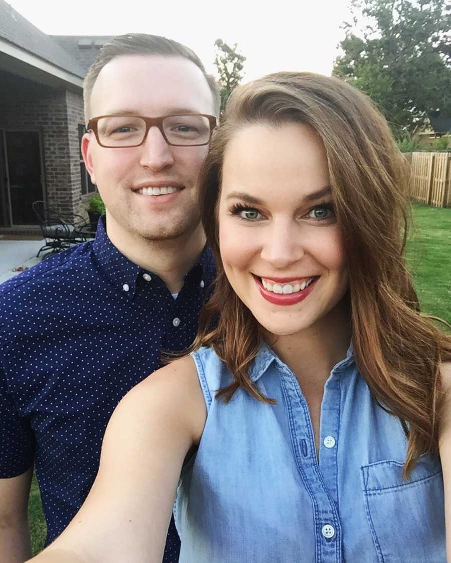 Husband and wife who want to adopt smile in selfie in backyard 