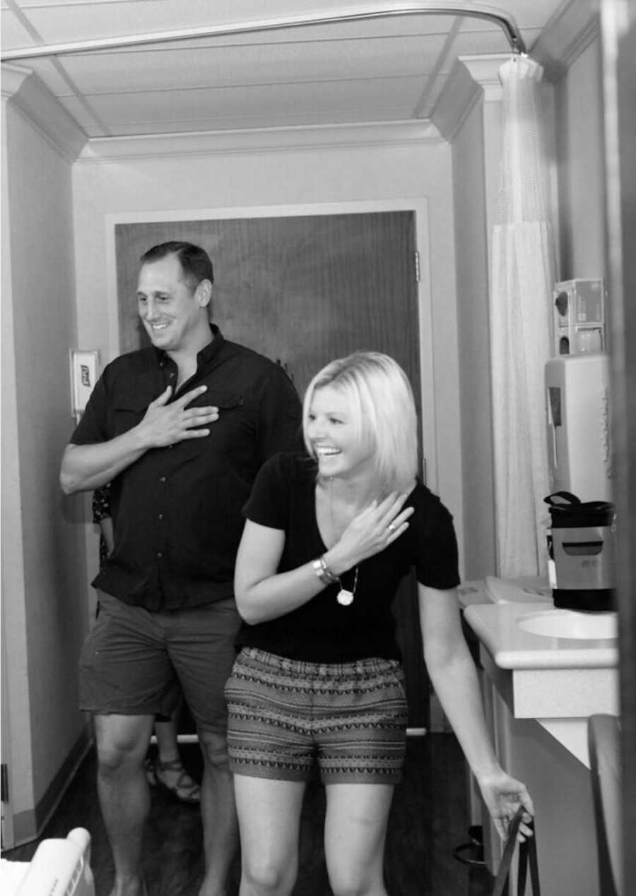 Husband and wife smile as the enter hospital room where their child is being born