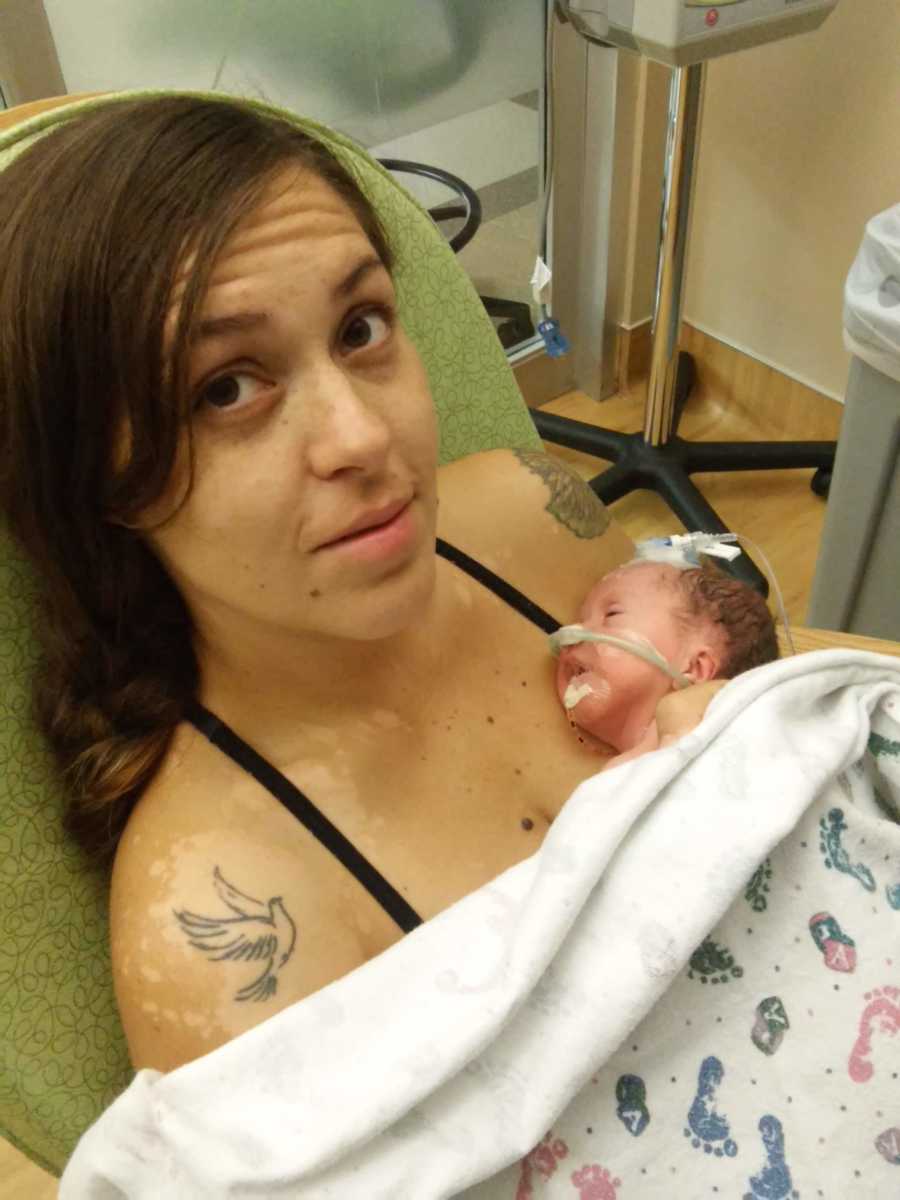 Mother who gave birth to her child naturally sits in NICU with newborn laying on her chest