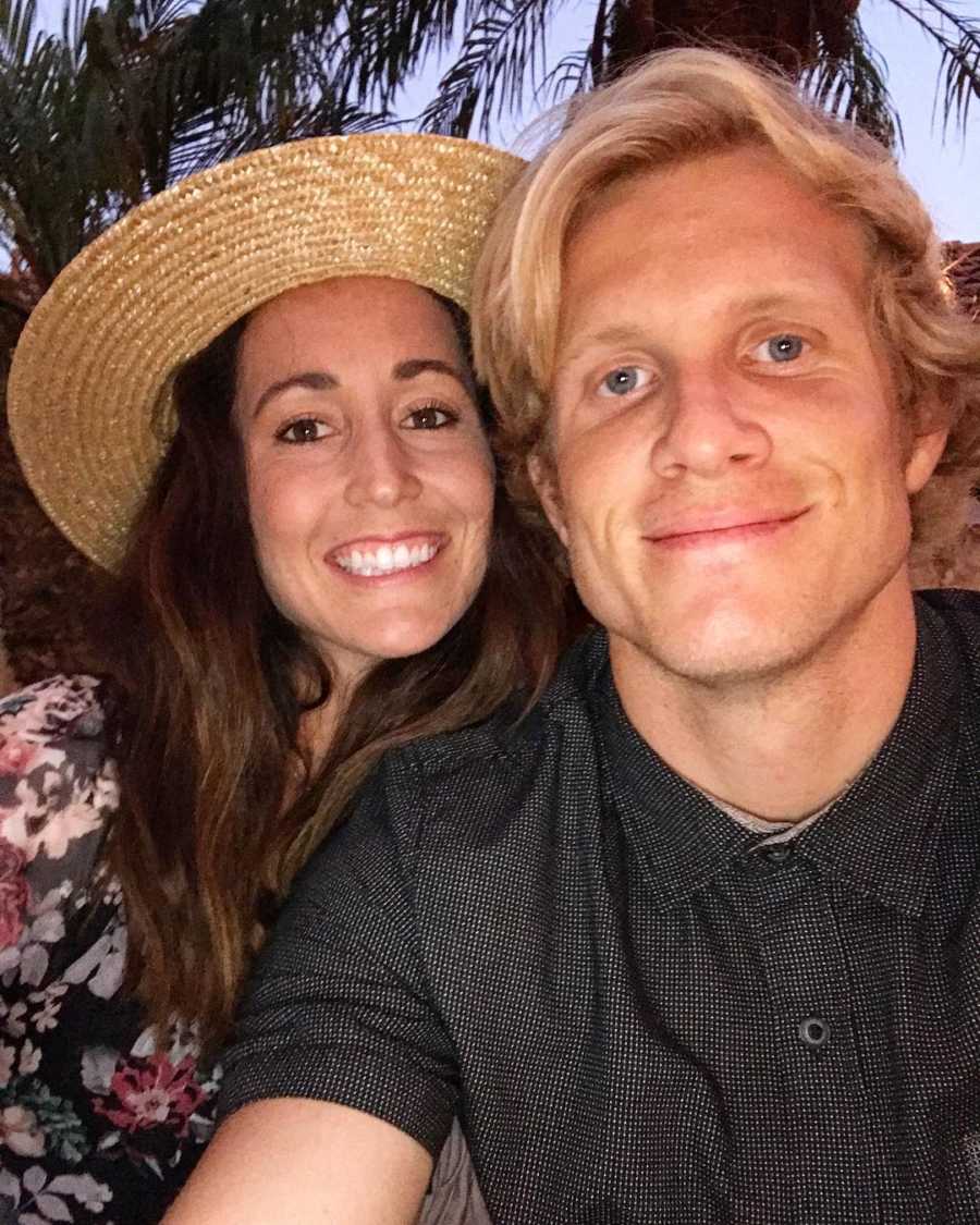 Husband and wife smile in selfie with Palm Trees in background