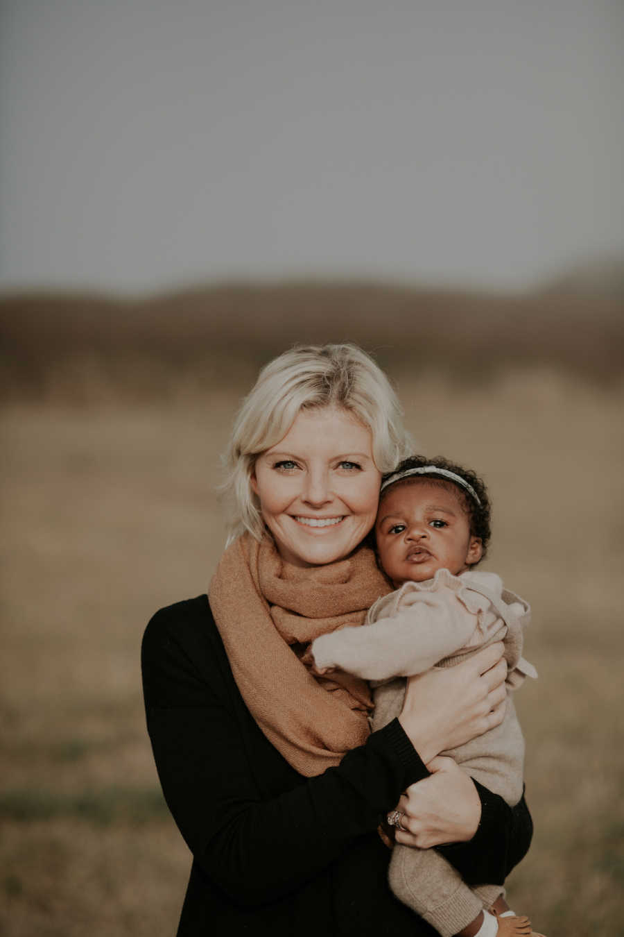 Woman smiles as she holds adopted baby
