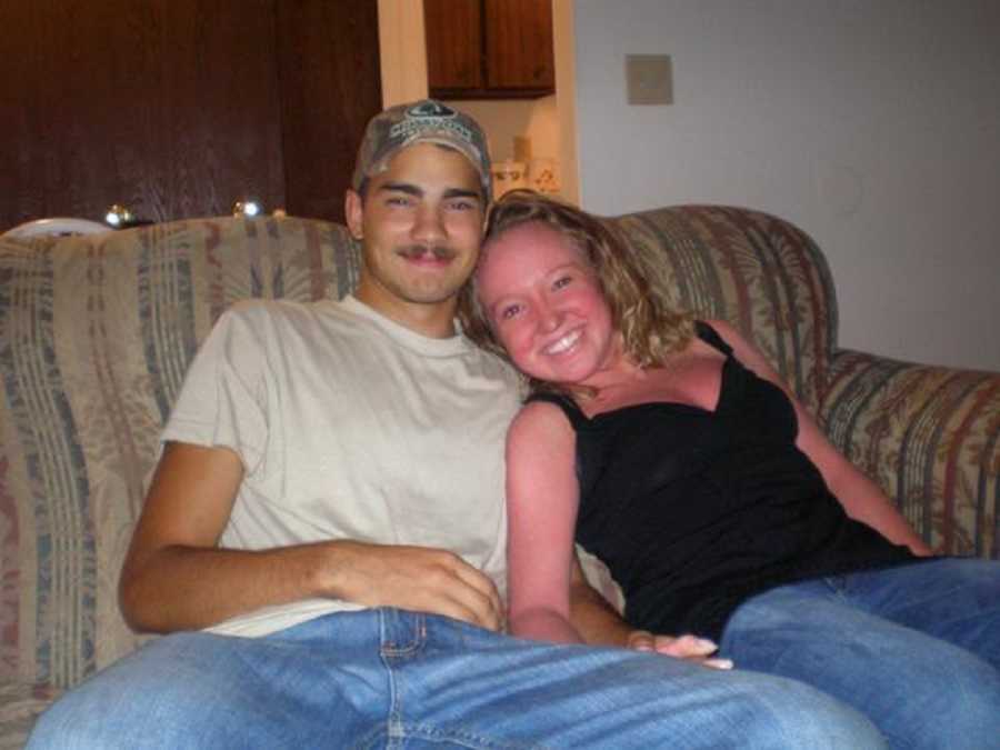 Young woman with Ichthyosis sits on couch smiling beside her boyfriend