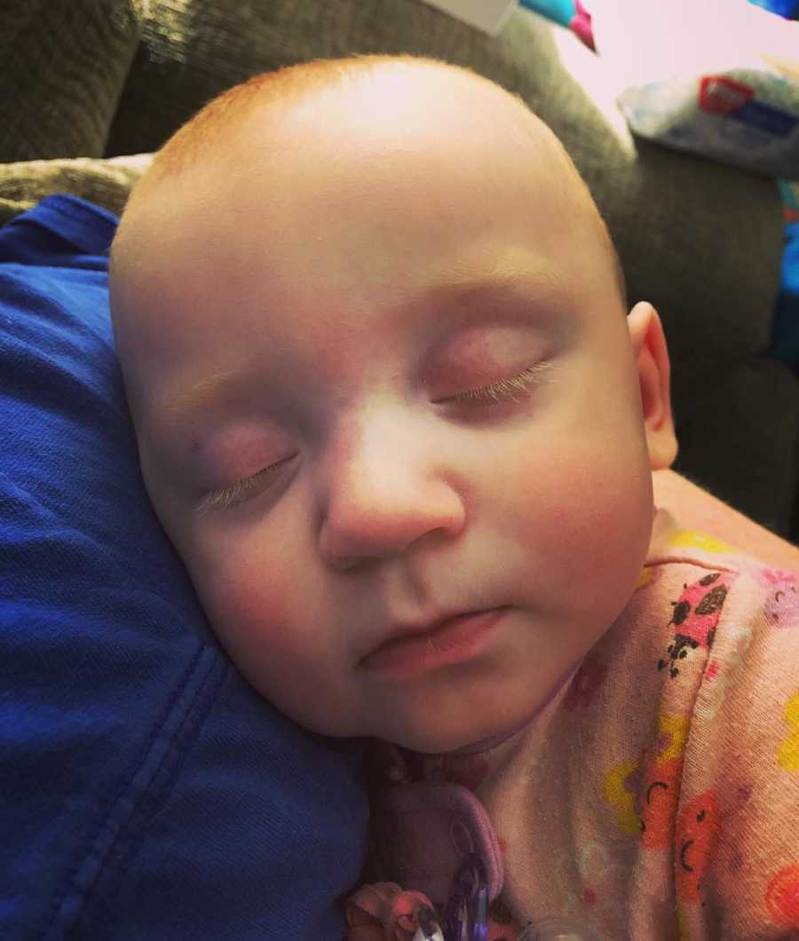 Baby girl lays on sleep on parents shoulder