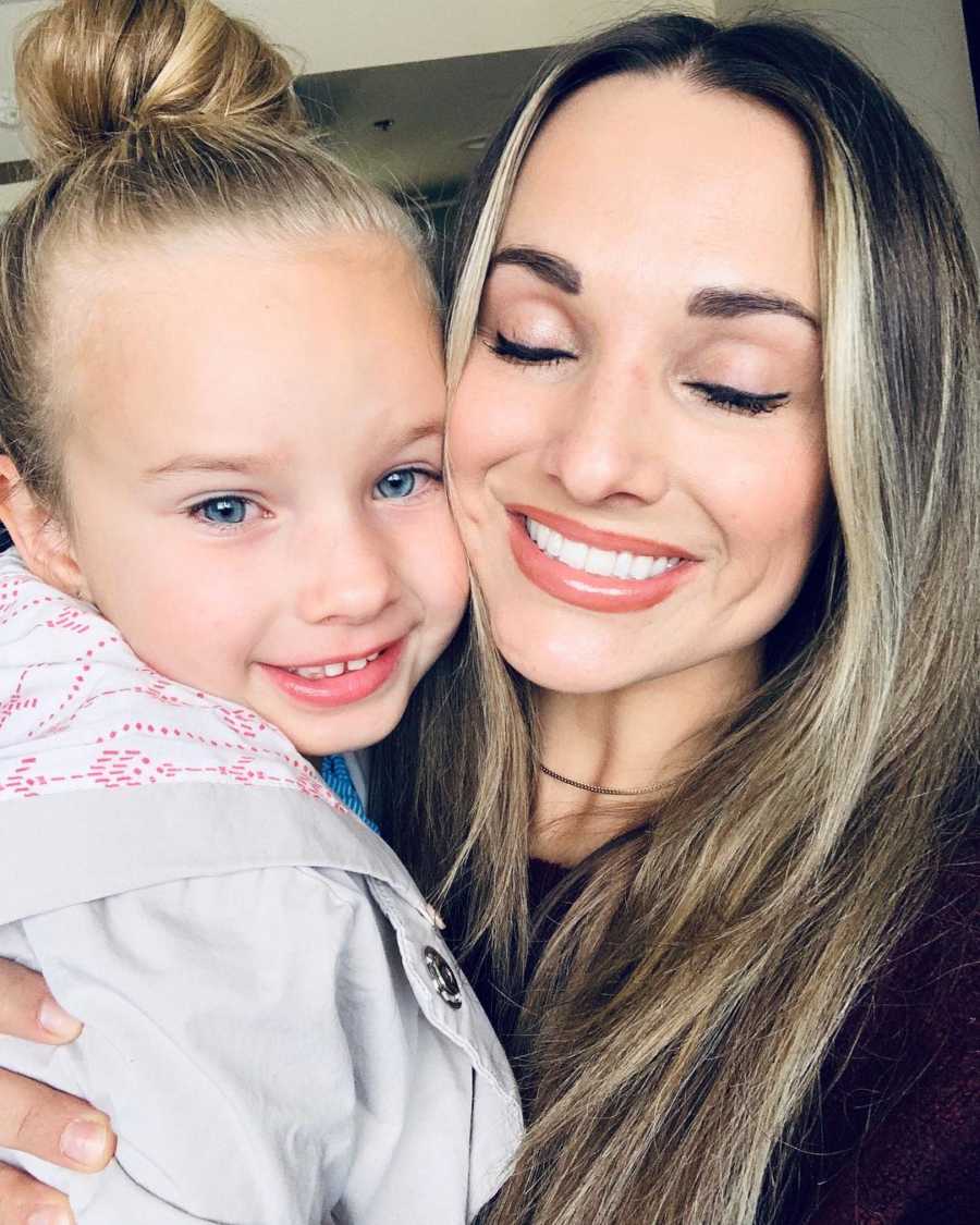 Mother smiles in selfie as she holds daughter