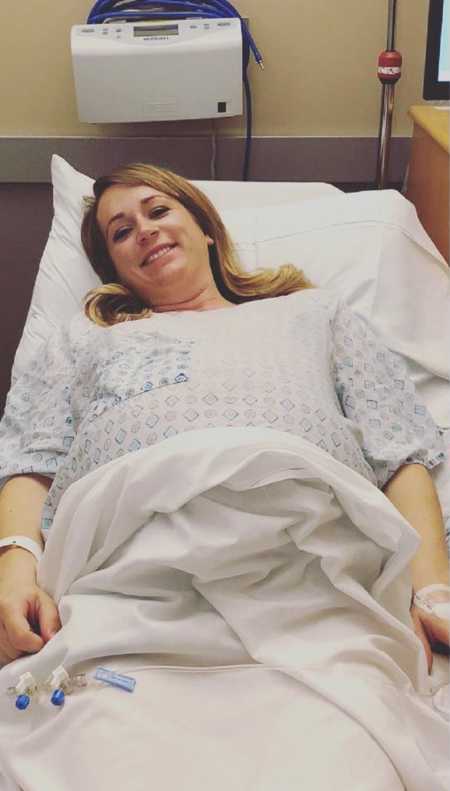 Pregnant woman lays smiling in hospital bed