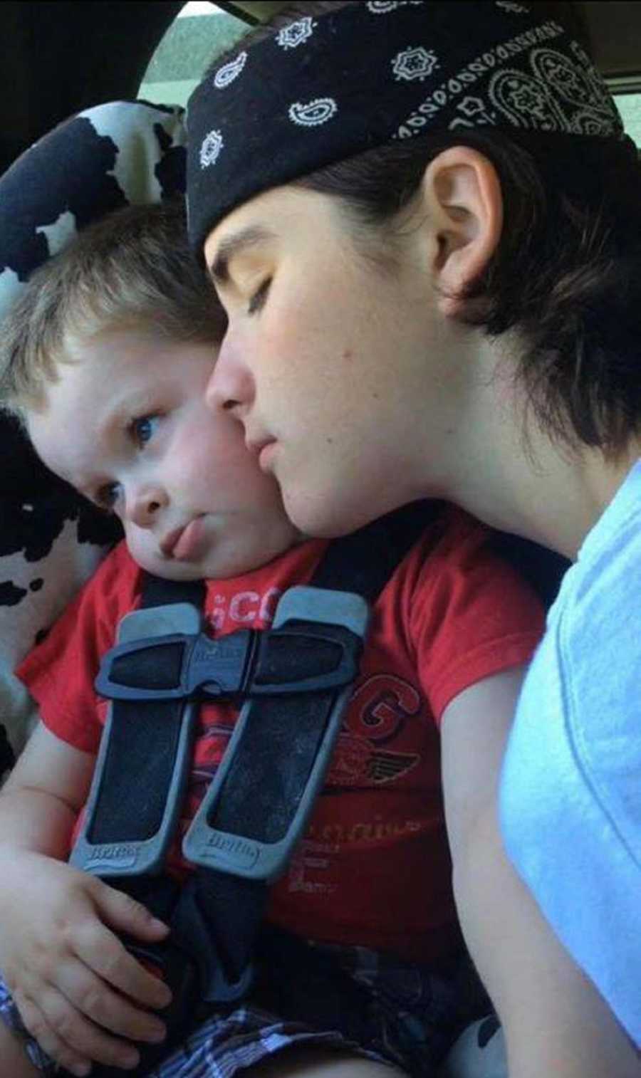 Young man who died from drug overdose leans head on younger brother who sits in car seat 