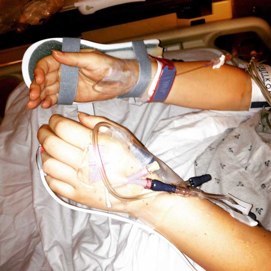 Woman's hands with bandages and IV's connected to them after she almost died giving birth