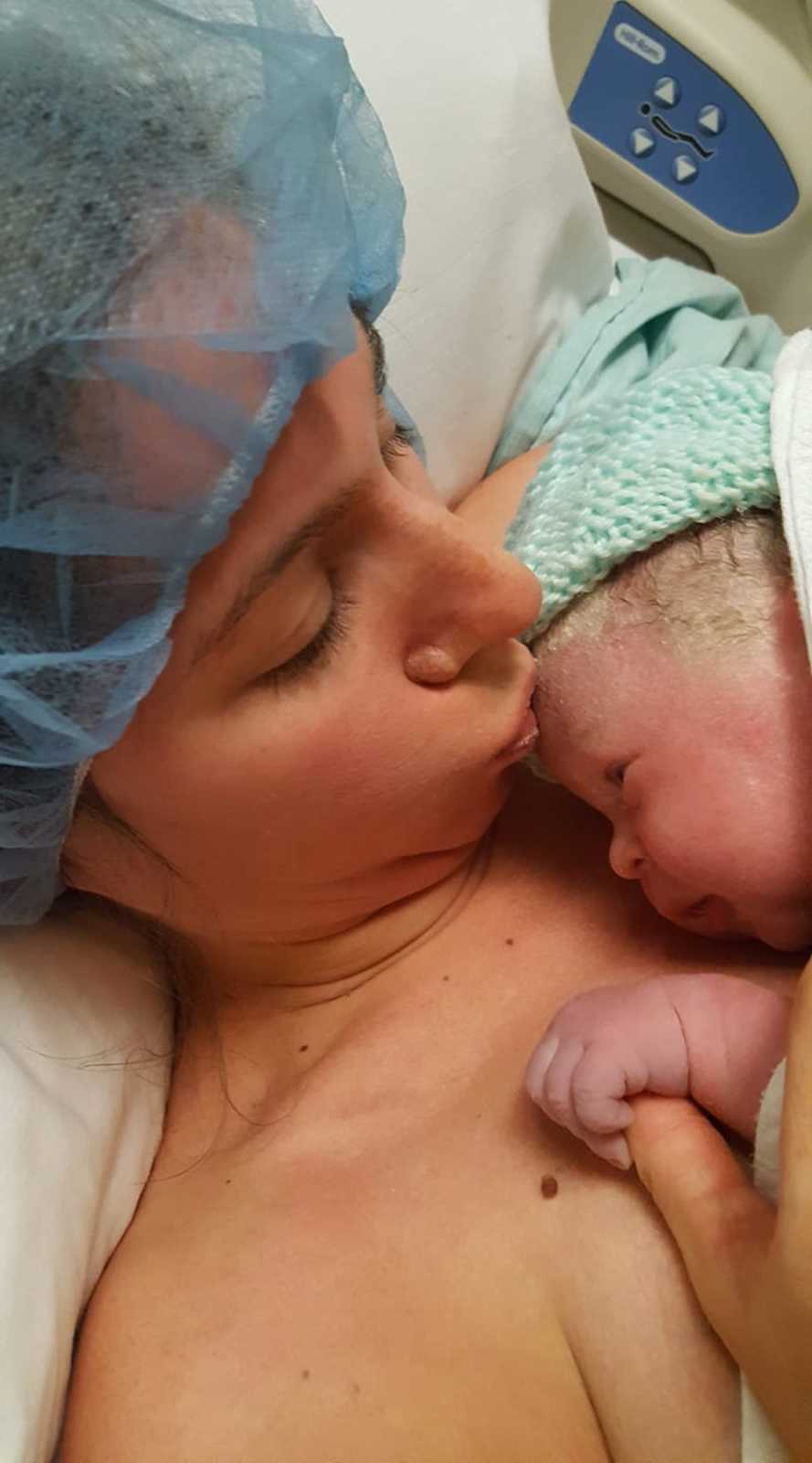 Mother who says time flies lays in hospital bed kissing forehead of newborn