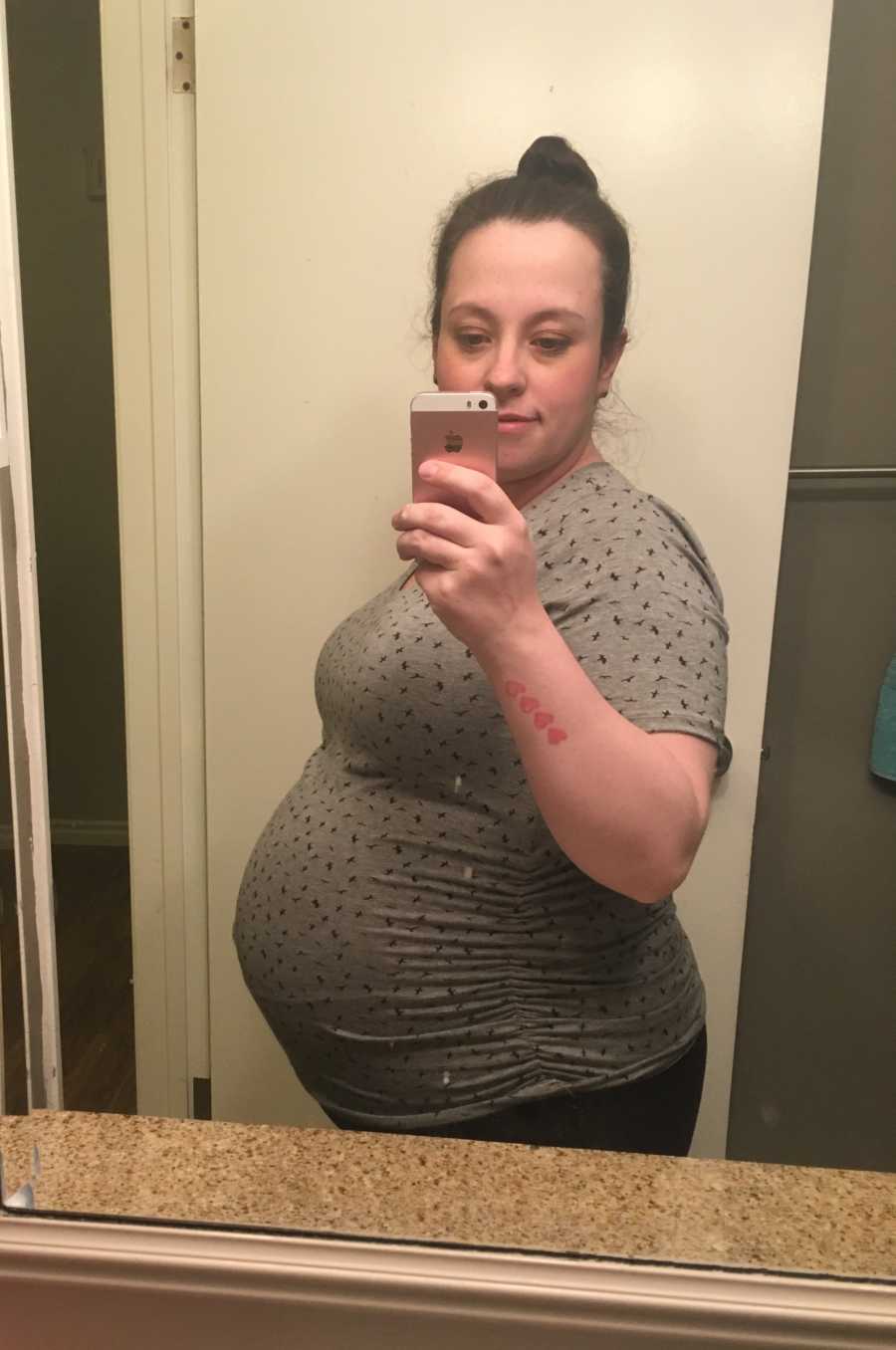 Pregnant woman takes mirror selfie in bathroom