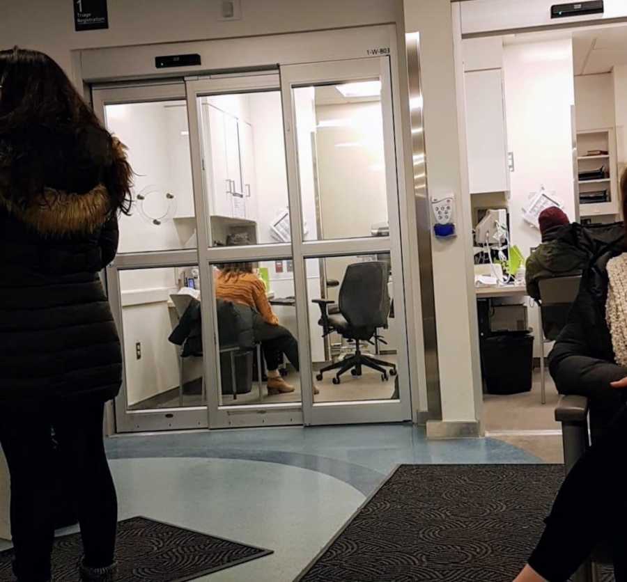 Waiting room of ER where woman sits waiting for her sick baby