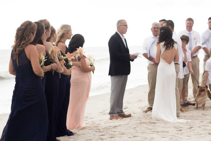 Bride and groom stand beside each other at altar of beach wedding