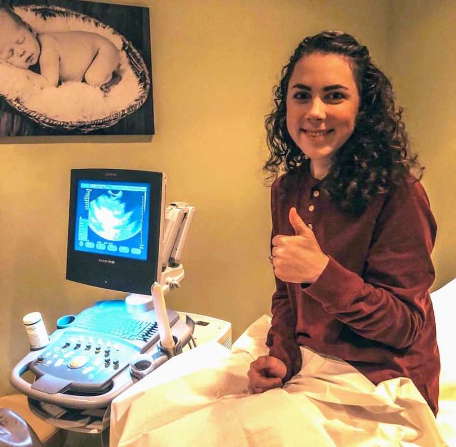 Woman who miscarried sits at ultrasound appointment with thumbs up