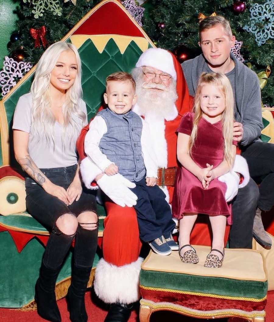 Separated couple sit on either side of mall Santa who has their son and daughter on his lap