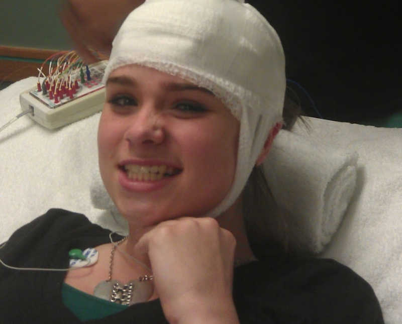 Teen who has seizures smiles in hospital bed with bandages wrapped around her head