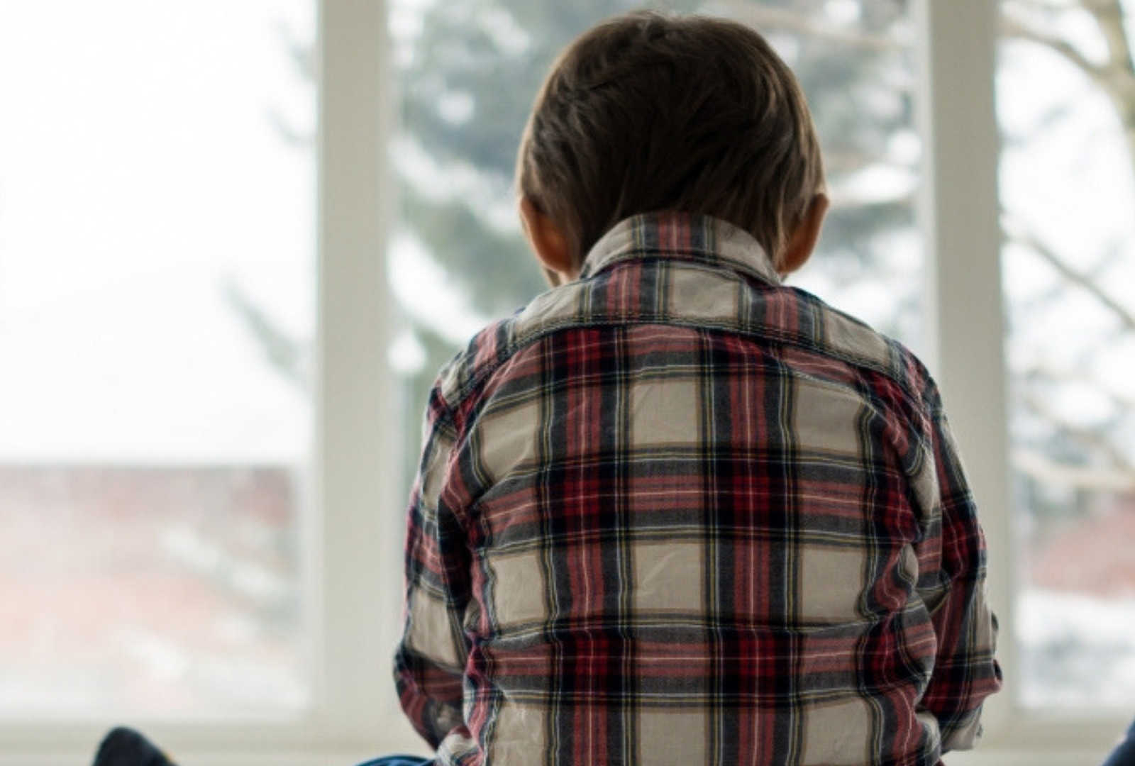 Back of little boy wearing flannel shirt whose mother says his behavior can be bizarre