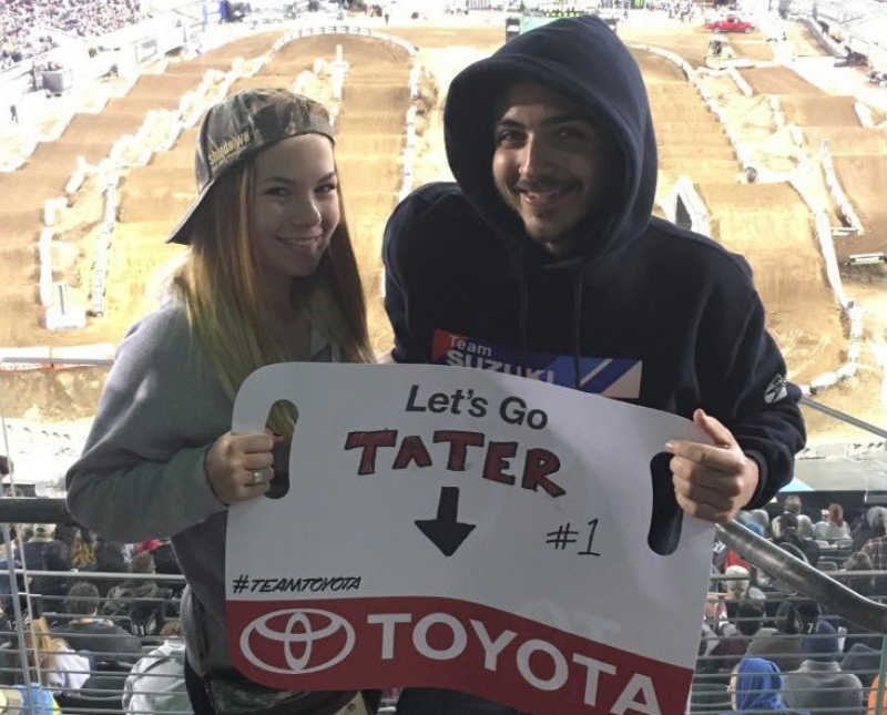 Cousins hold sign at dirt bike competition