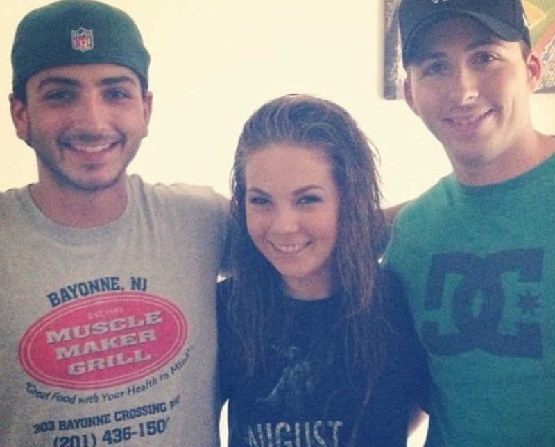 Teen smiles with her boy cousins on either side of her