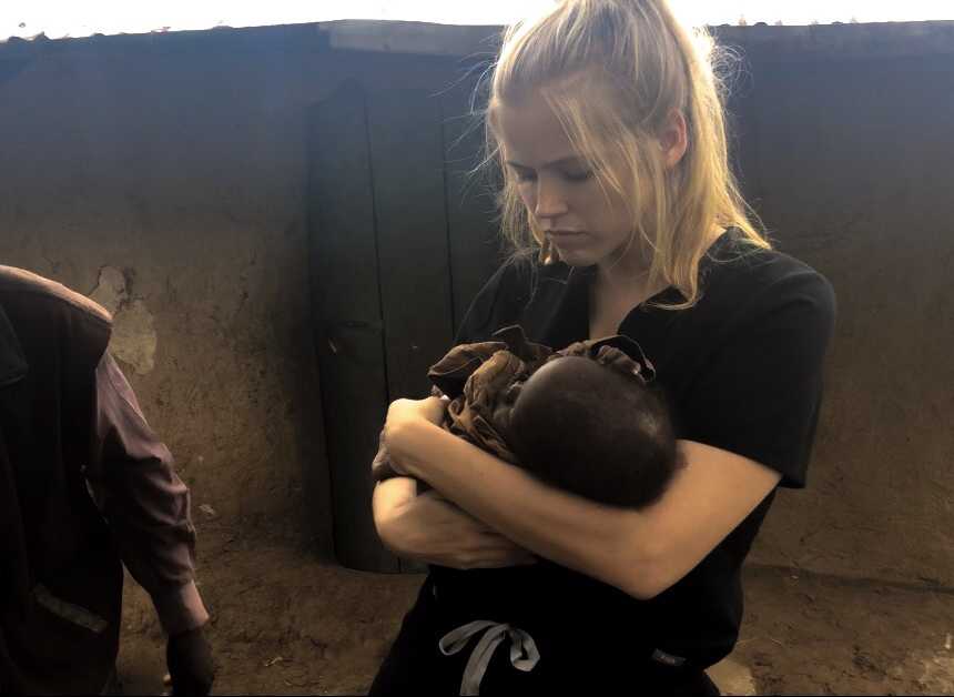 Woman holds baby orphan in her arms