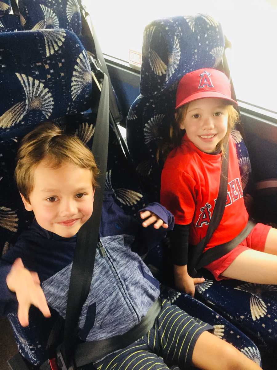 Brother and sister sit smiling on coach bus before being diagnosed with brain surgery
