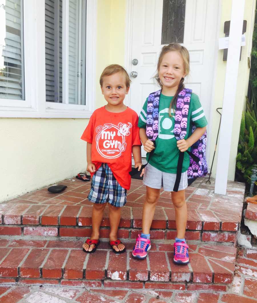 Little boy and girl stand smiling on steps outside of home before being diagnosed with cancer