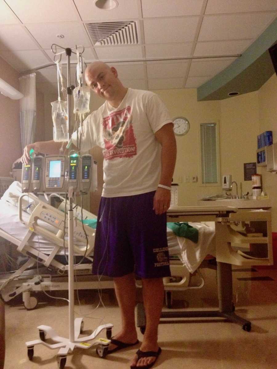 Man with tumor in his chest stands in hospital room hooked up to monitors